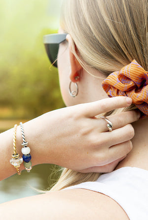 Model wearing Trollbeads bangles with beautiful little jewelry beads, and Trollbeads earrings and a ring