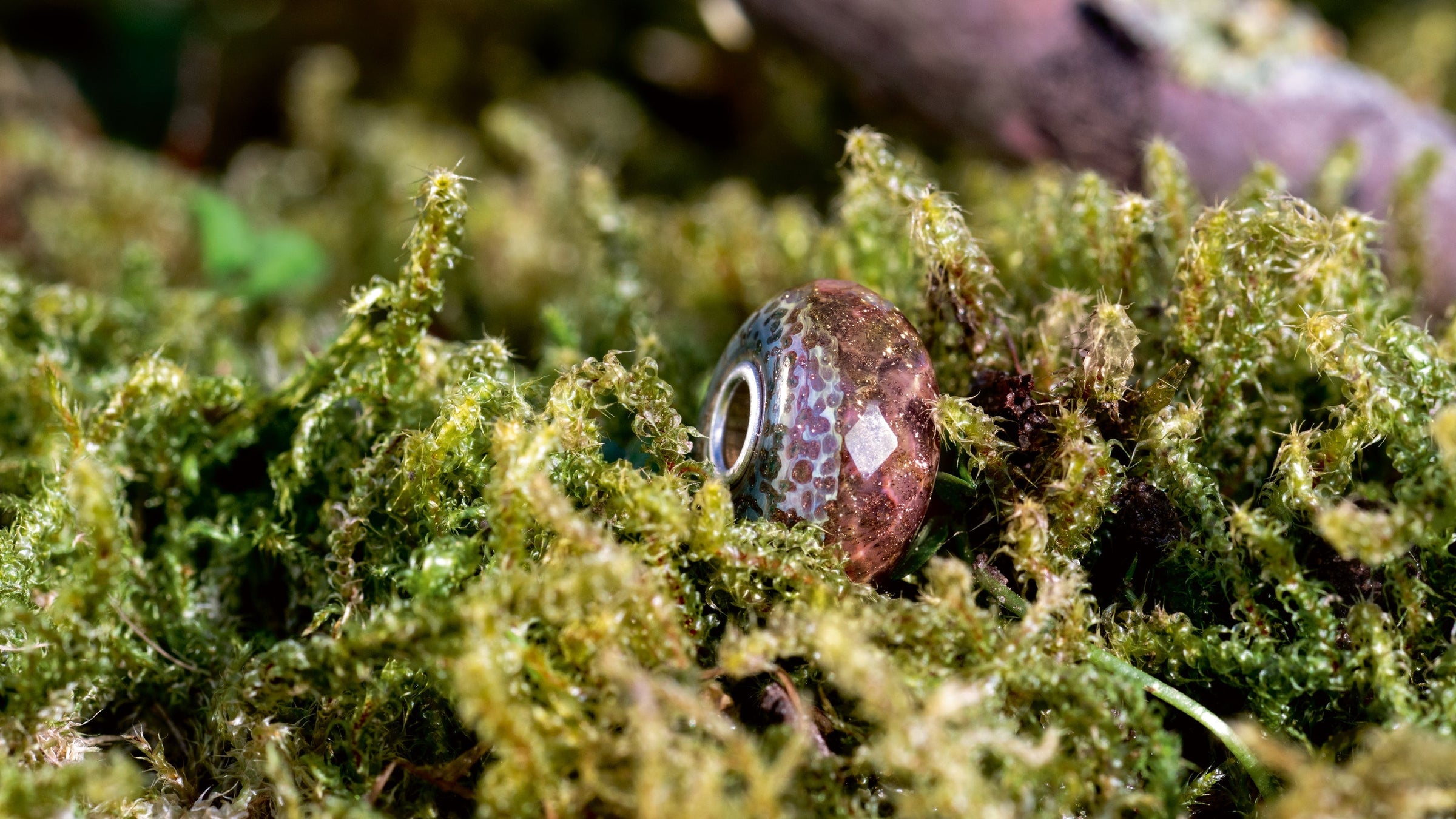 Troll Agate bead standing on moss
