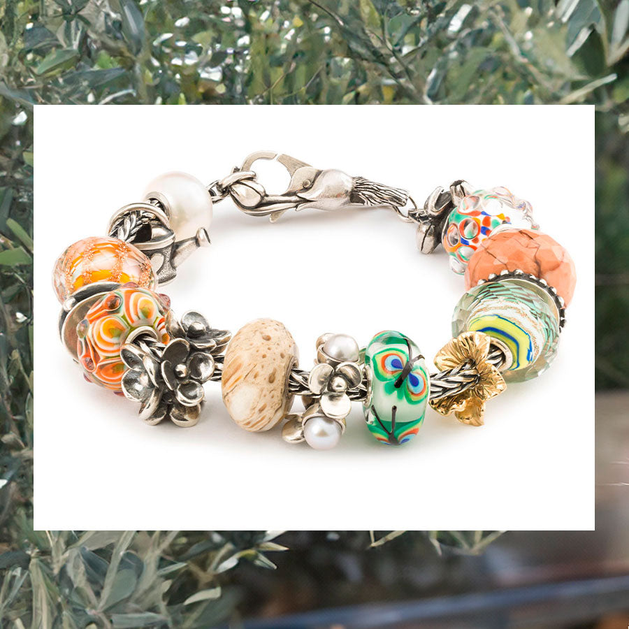 Trollbeads Foxtail Armband mit Beads Connectors und einem Schloss aus der Nurtured Connections Kollektion auf einem Hintergrund mit Olivenbäumen